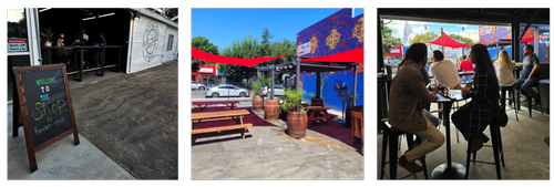 Sliding door open and chalkboard sign, Outside patio with picnic benches and red shade sails, people sitting inside Rendez-vous Winery